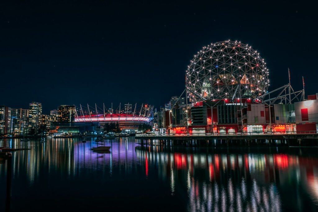 Vancouver: The Perfect Blend of Urban and Natural Beauty - skyline photography of boat passing on waters overlooking buildings